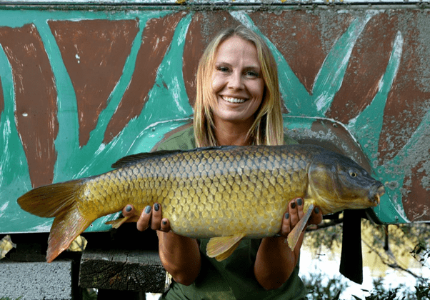 Image of Bev with her carp capture - Image taken from @BeverleyCliffordAngler (Facebook)